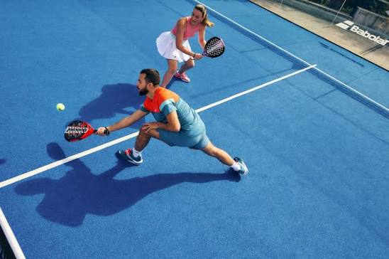 Padelspeler met racket op de baan